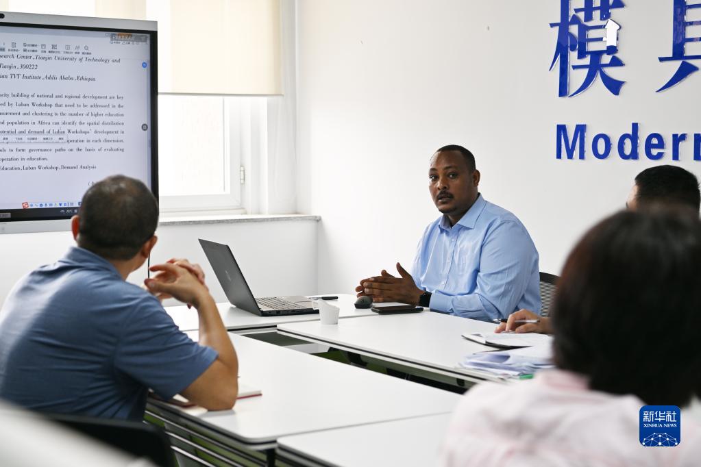 在天津職業(yè)技術師范大學，韓士蘭（中）和老師們交流（8月12日攝）?！⌒氯A社記者 李然 攝