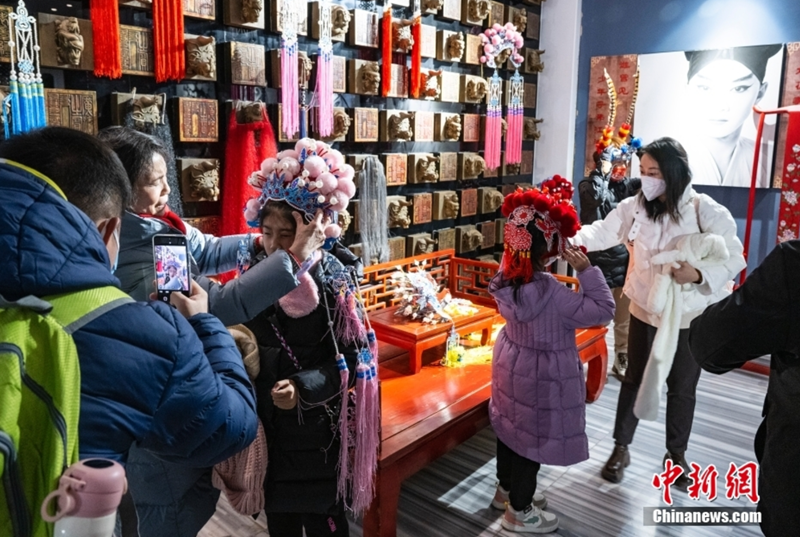 圖為小朋友們?cè)诩议L(zhǎng)的“指揮”幫助下體驗(yàn)部分京劇服飾。 中新社記者 侯宇 攝