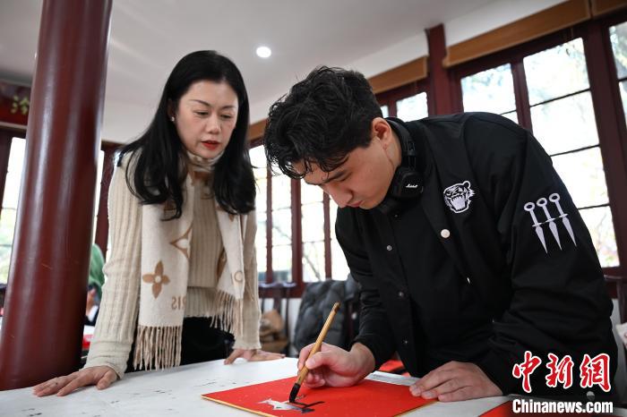 1月20日，外籍留學(xué)生在西泠印社社員李硯指導(dǎo)下寫(xiě)福。當(dāng)日，來(lái)自巴西、馬來(lái)西亞、加納、哈薩克斯坦的外籍留學(xué)生在浙江杭州西泠印社體驗(yàn)福貼、春聯(lián)和篆刻，感受古老的中國(guó)傳統(tǒng)文化。中新社記者 王剛 攝