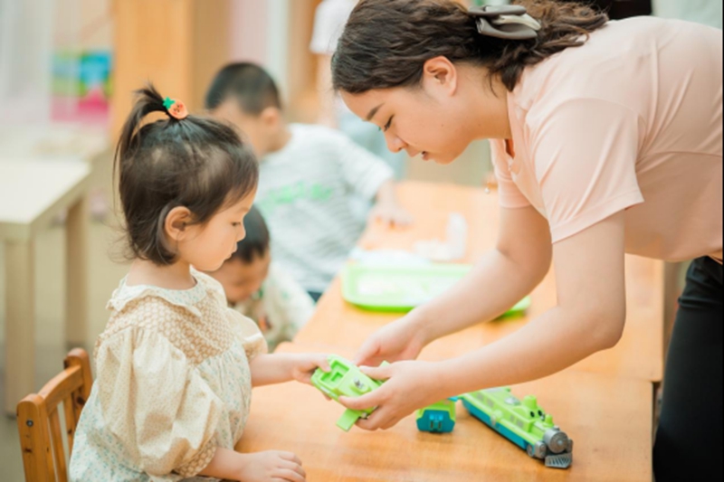 教師與孩子一起玩玩具。園方供圖