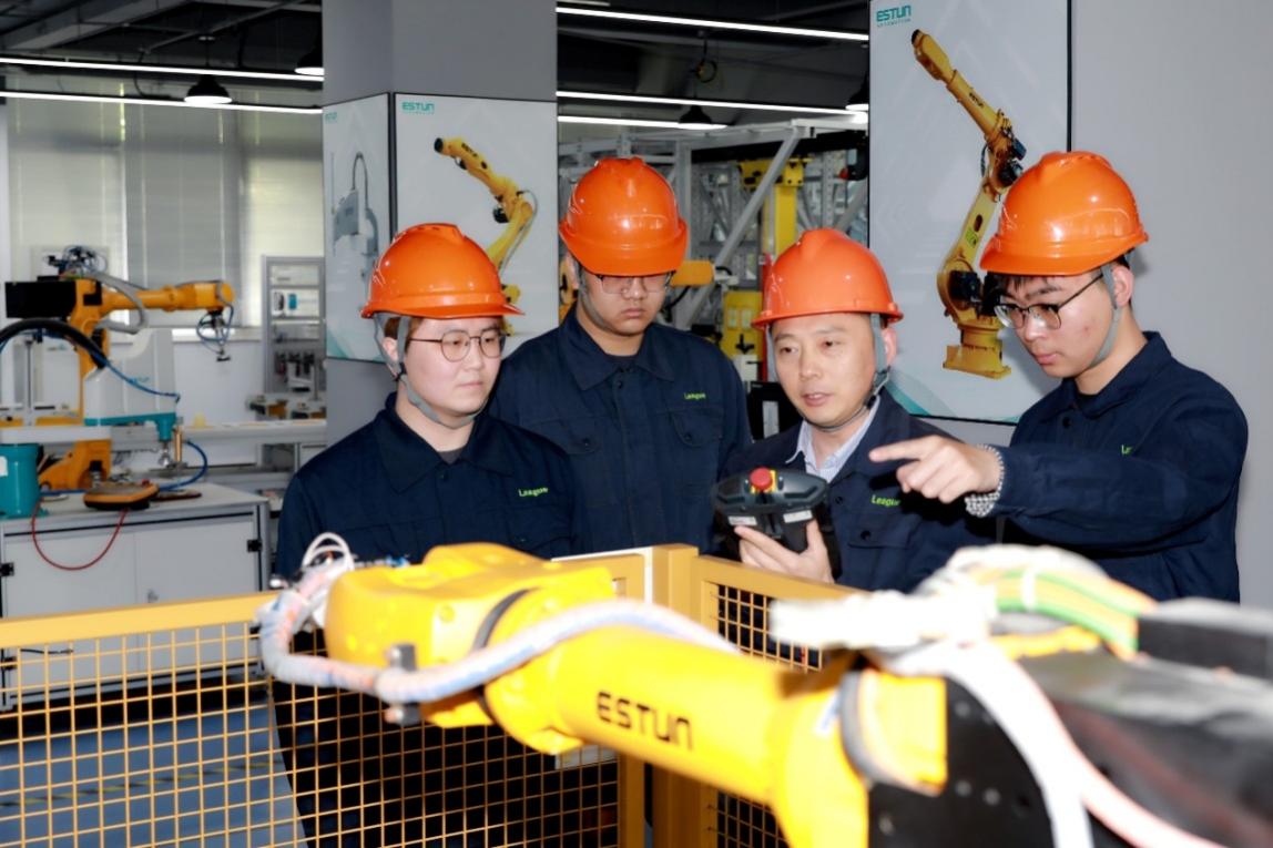 教師正在指導(dǎo)企業(yè)員工進(jìn)行機(jī)器人編程與運(yùn)維。學(xué)校供圖