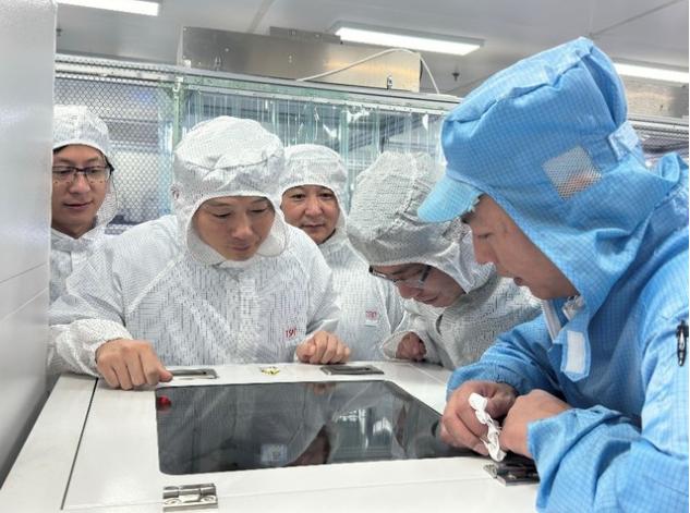 教師正在指導(dǎo)企業(yè)員工分析設(shè)備運(yùn)行曲線。學(xué)校供圖