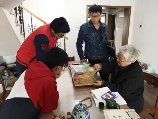 2019年，岳同給來(lái)家看望的志愿者們展示收藏的剪紙、中國(guó)畫(huà)作品。中國(guó)人民大學(xué)供圖