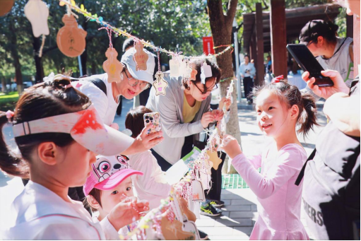 兒童和家長一起懸掛“環(huán)保心願倡議”卡片。中國兒童中心供圖