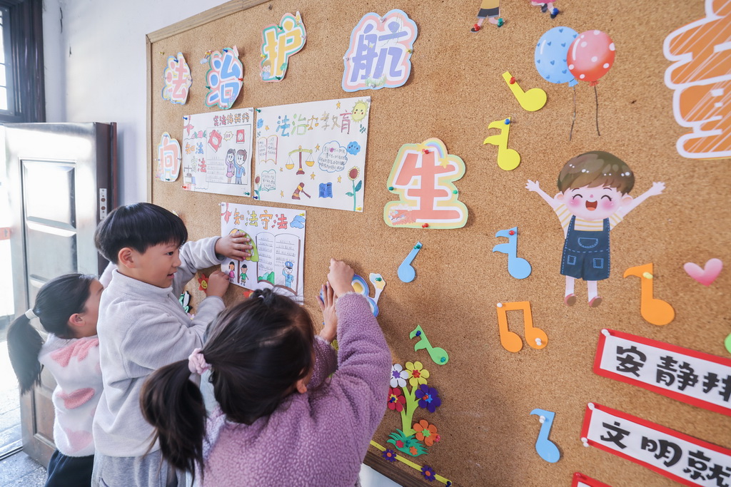 12月9日，諸暨市暨南街道中心學校王家井小學的學生把自己創(chuàng)作的法治宣傳畫貼到教室的宣傳欄中。