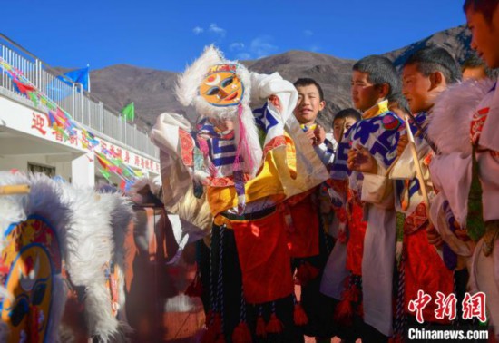 圖為加查縣安繞鎮(zhèn)小學學生在試穿藏戲面具?！∝暩聛眢?攝