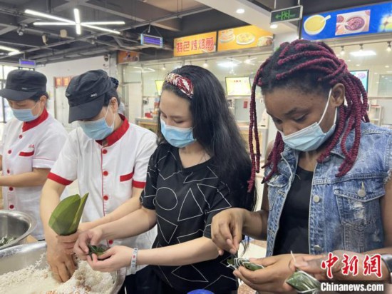 圖為留學生們嘗試包粽子?！堟鸿?攝