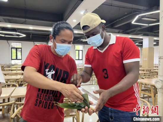 圖為留學生們嘗試包粽子?！堟鸿?攝