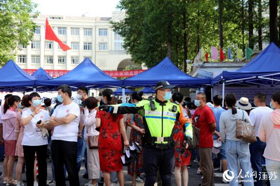 交警在南京田家炳中學(xué)考點(diǎn)附近指揮交通。人民網(wǎng) 冷金明攝