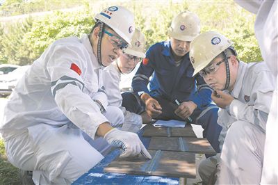 楊建(左一)為焊工考試人員點評考試件。 戴世超攝