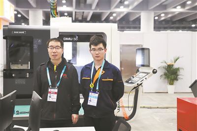  沈德章（左）和學(xué)生在全國(guó)職業(yè)技能大賽賽場(chǎng)。 受訪者供圖