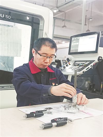 沈德章對(duì)學(xué)生加工的產(chǎn)品進(jìn)行測(cè)量、評(píng)定。受訪者供圖