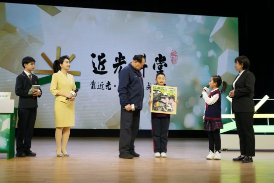 平谷六小版畫社團(tuán)的學(xué)生代表贈送手工作品《平谷彩韻》，展現(xiàn)了平谷桃花海美景。