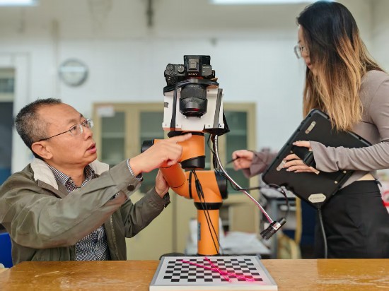 孫江宏教授正與團(tuán)隊(duì)成員測(cè)試割膠機(jī)器人性能