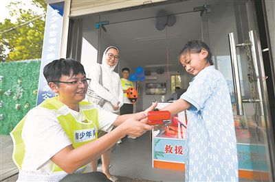 在江蘇省泰州市海陵區(qū)東河小游船碼頭“青少年防溺水救助站”旁，小朋友體驗(yàn)水下救生速浮手環(huán)。