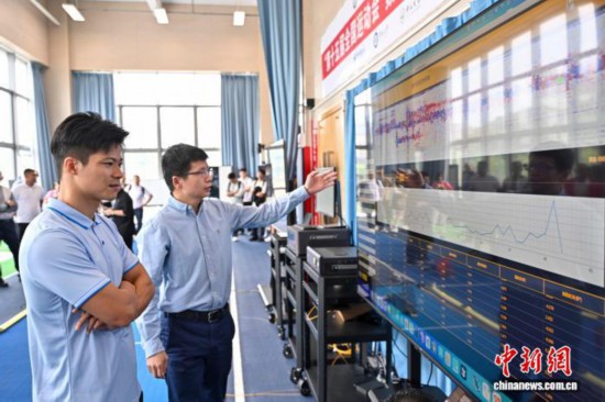 圖為蘇炳添在訓(xùn)練基地內(nèi)了解數(shù)字化跑道分析系統(tǒng)。中新社記者 陳驥旻 攝