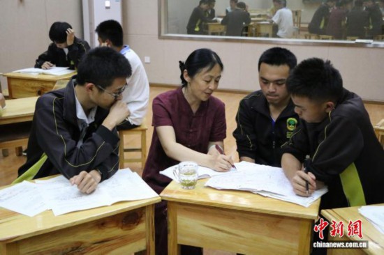 2017年5月3日，王潔(左二)正在輔導梁河一中學生。受訪者 供圖