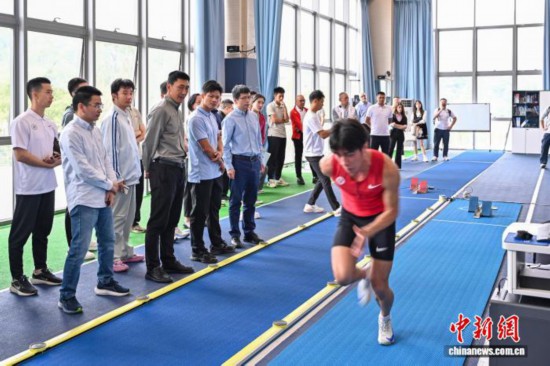 圖為蘇炳添在訓(xùn)練基地內(nèi)了解數(shù)字化跑道分析系統(tǒng)。中新社記者 陳驥旻 攝