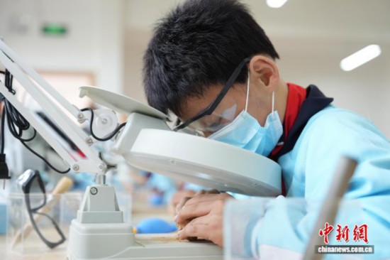 一名小學生正在清理“化石”上的泥土。劉鴻鶴 攝