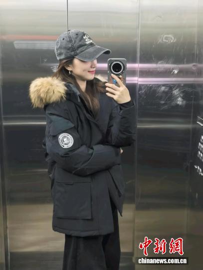 張洛齊身著今年“雙十一”剛開啟時買的羽絨服，這件羽絨服原價890元，折后830元買的。 受訪者供圖